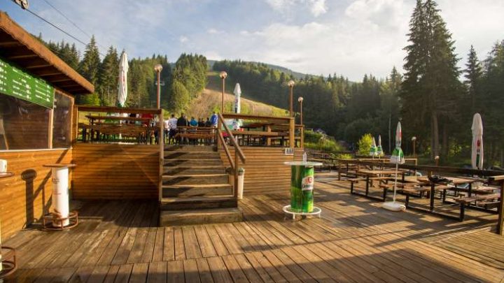 the wooden terrace of the restaurant during the summer season photographed from the lower side